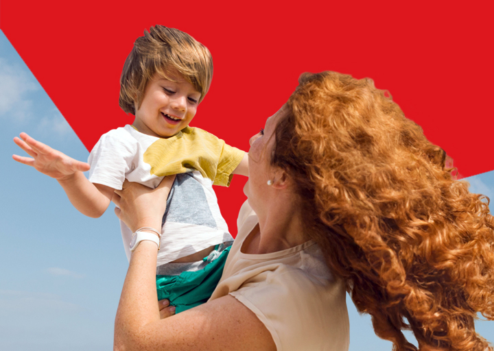 Photo of a mother holding her child representing the positive impact that National Bank has in people’s lives 