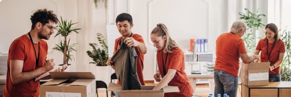 Photo of people folding clothes in a donation centre 