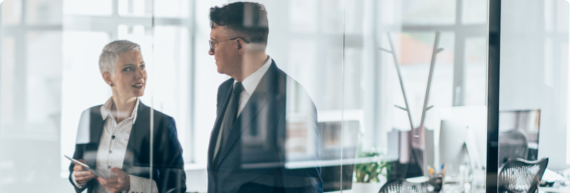 Photo of a business man and woman speaking in a conference room