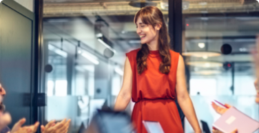 Photo of a woman standing up, speaking to her colleagues 