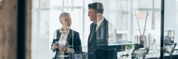 Photo of two people speaking in an office 
