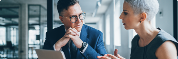 Photo of two people speaking in an office