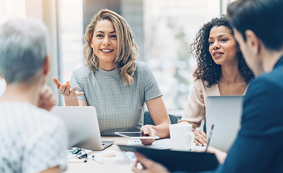 Photo of a group of four discussing something during a meeting