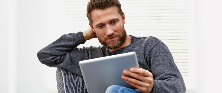 Photo of a woman sitting at a table and working on her laptop 