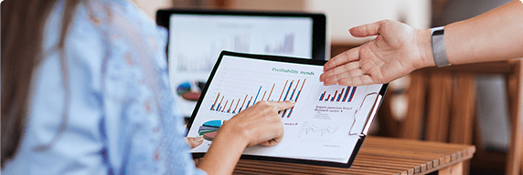 Photo of two people talking while looking at a graph