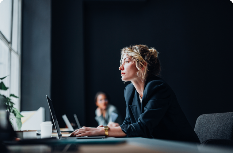 Photo of a person working on their laptop in an office