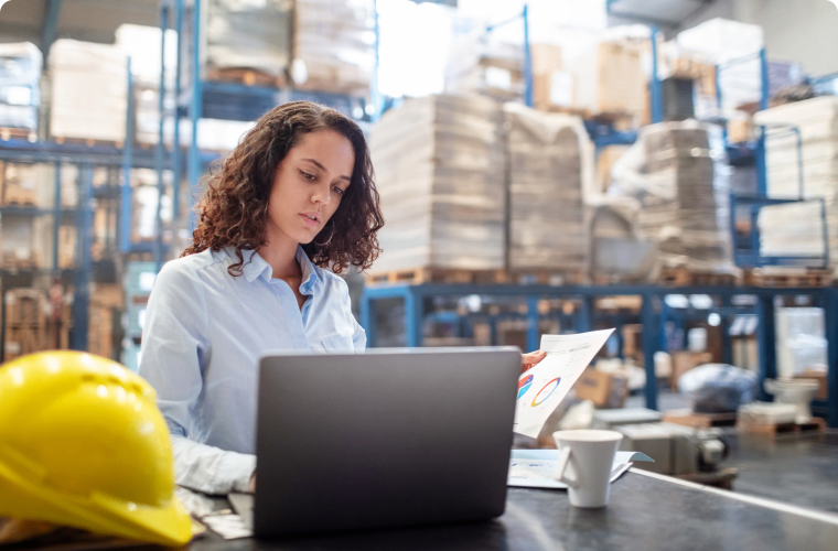 Photo of an entrepreneur in a warehouse looking at their computer