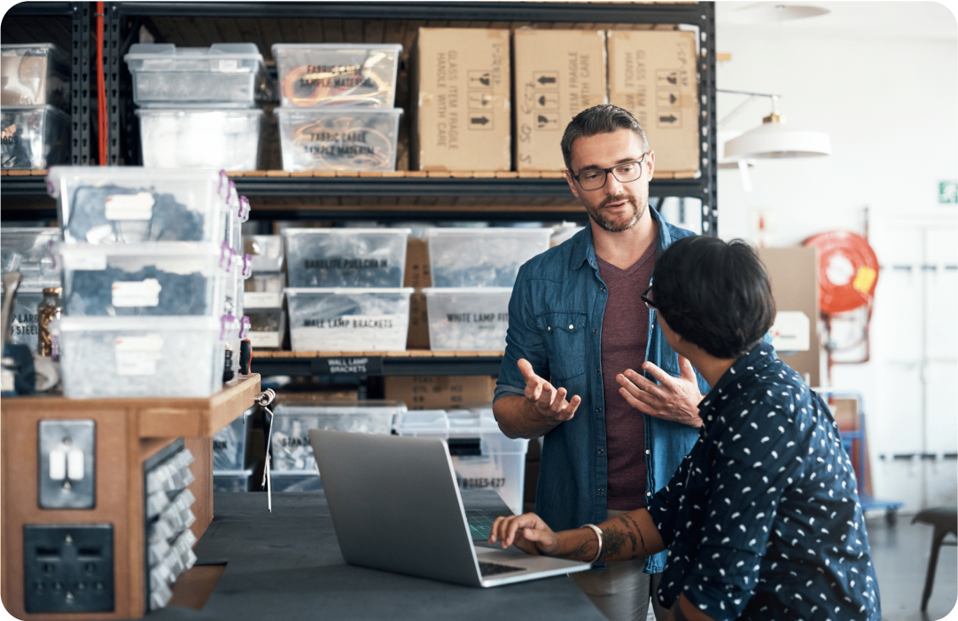 Photo of two people talking in a warehouse