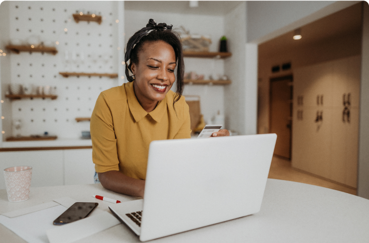 Photo of a person using their credit card while working on their laptop in a workshop 