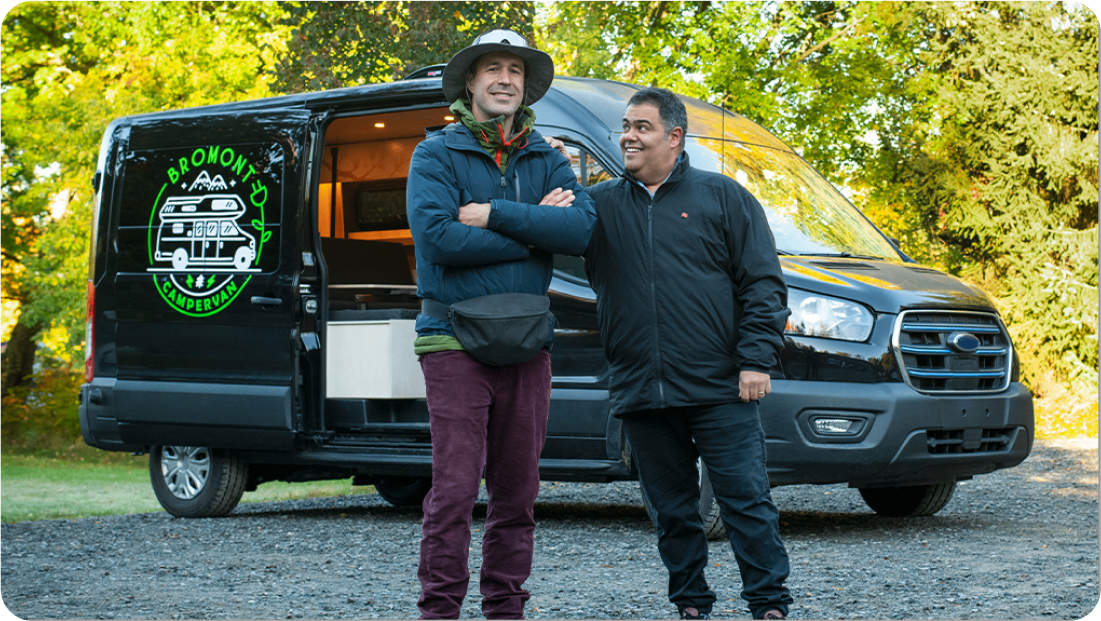 Photo of a National Bank advisor and their client smiling next to a minivan equipped for camping  