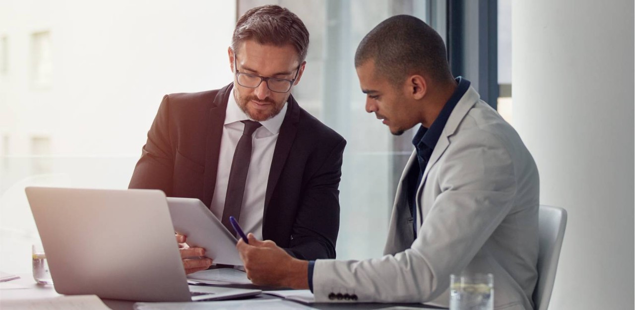 Photo of two people looking at documents in an office  