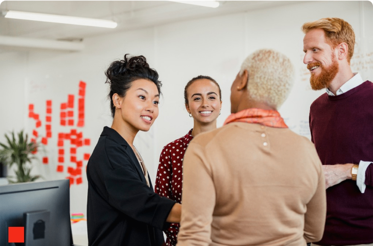 Photo of a group of people talking in an office