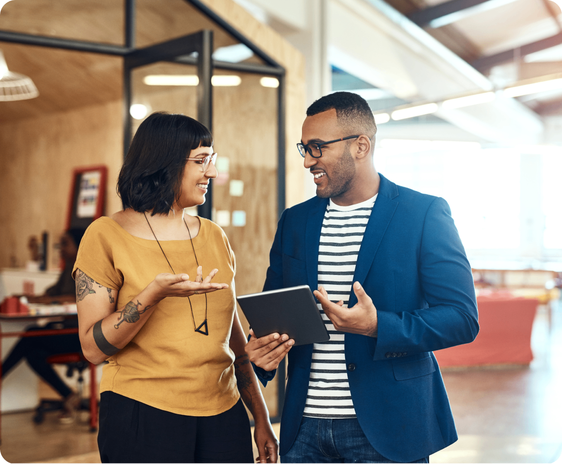 Photo of two people talking in the hallway of an office