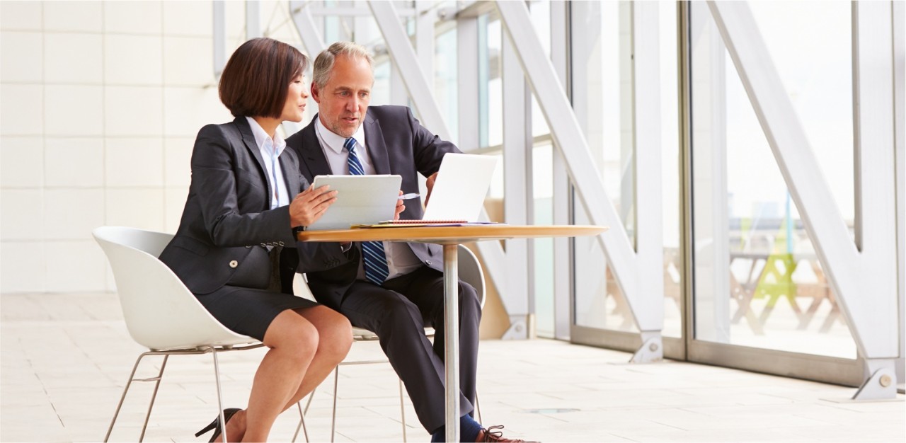 Photo of two businesspeople in an office discussing their global trade solutions