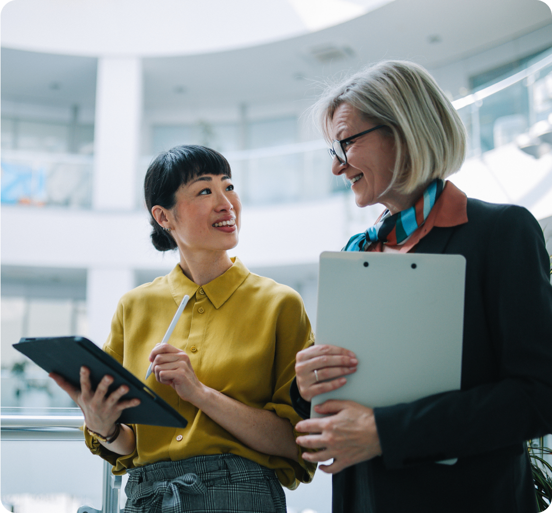 Photo of two people speaking in an office about their international business management