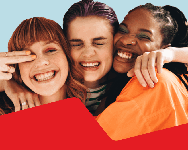 Photo of three young people smiling with their arms around each other 