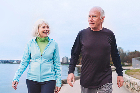 Photo of a retired couple walking by the water