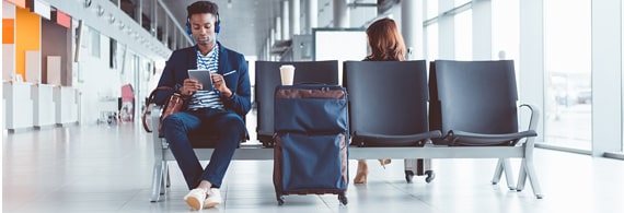 Man sitting at the airport with his luggage