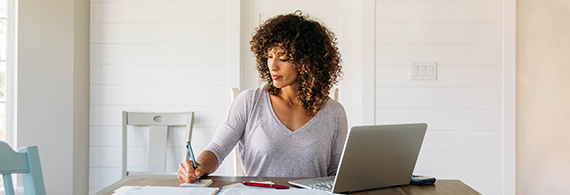 Young professional woman sitting at a table with her laptop open