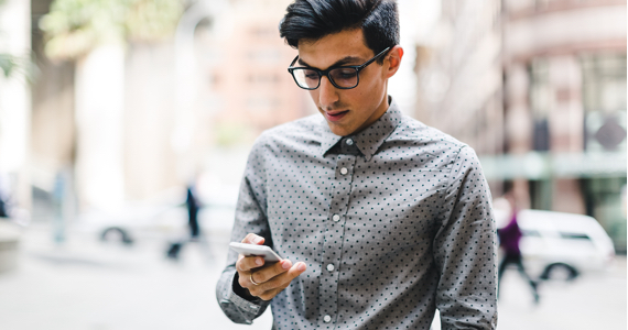 Man in the street looking at his phone