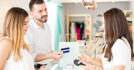 Young couple in a shop pays with a credit card