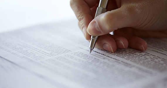 hand holding a pen and correcting a document