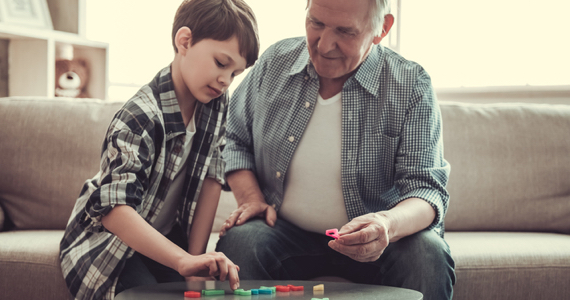 Little boy playing a game with his grandfather
