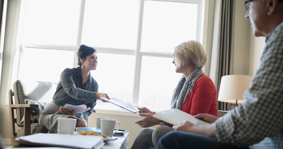 Advisor hands papers to a retired couple