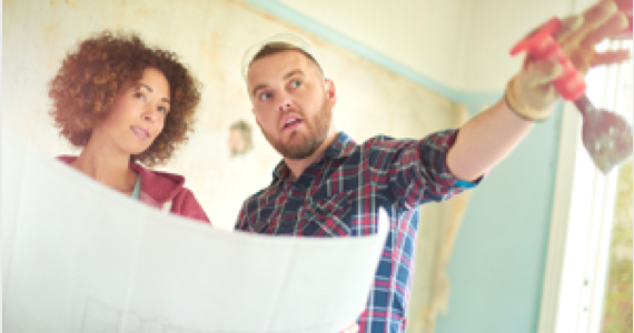 Young woman holding a floor plan talks with a young man