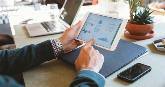 Man pointing at graphs on his tablet