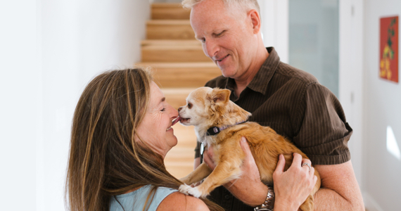 Retired couple holding a small dog