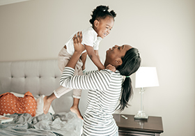 Woman playing with her daughter in her arms