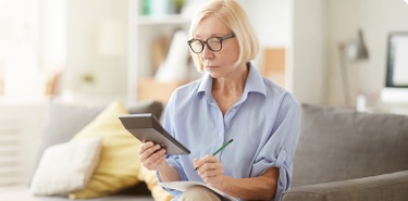 Woman wearing glasses looking at a calculator