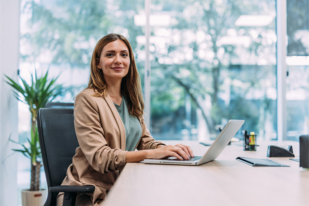 Photo of a woman on her computer learning about the importance of taking charge of her personal finances