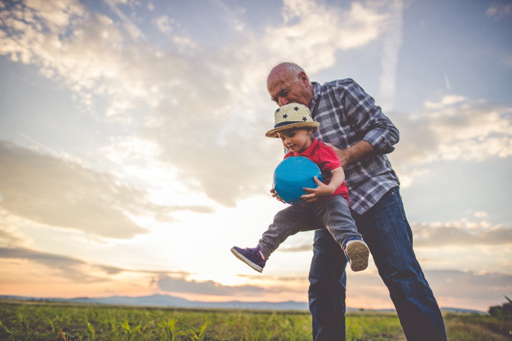 Retired man holding his grandson 