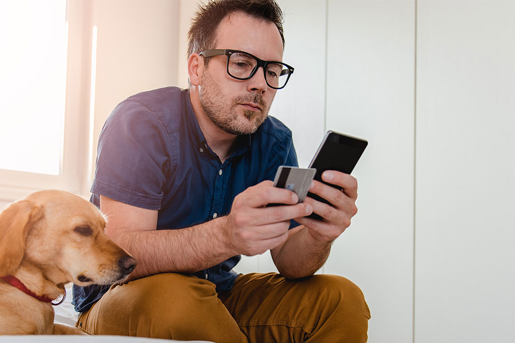 Photo of a man doing an online payment with his credit card