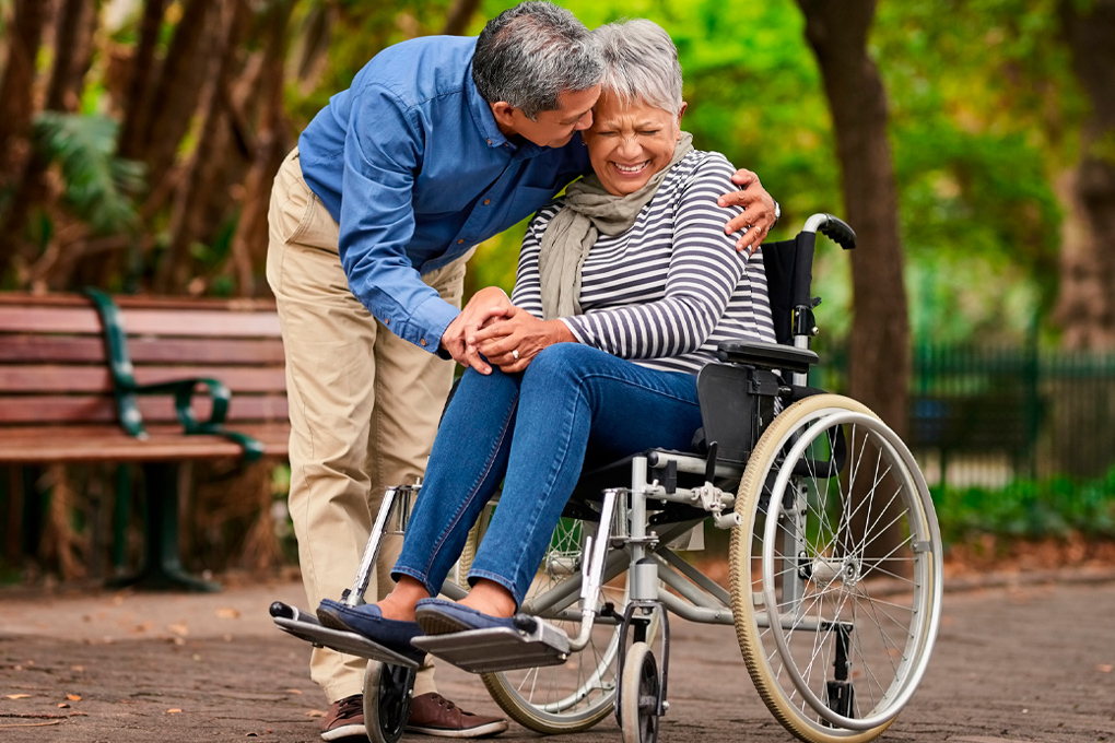 Photo of a man hugging a woman in a wheelchair