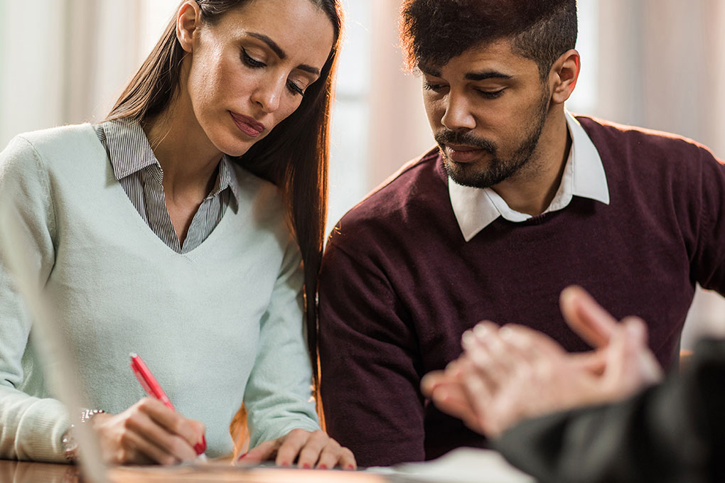 Man and woman signing divorce papers