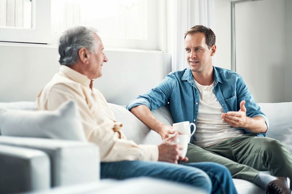 Two men talking on a couch