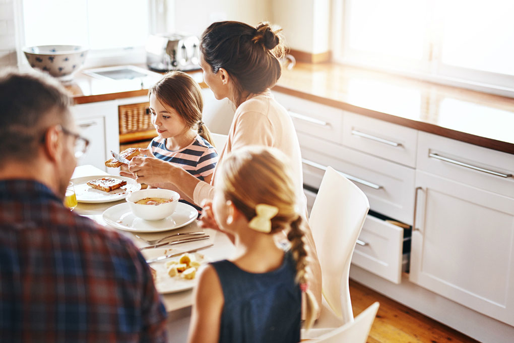 A couple breakfast in the kitchen with their kids