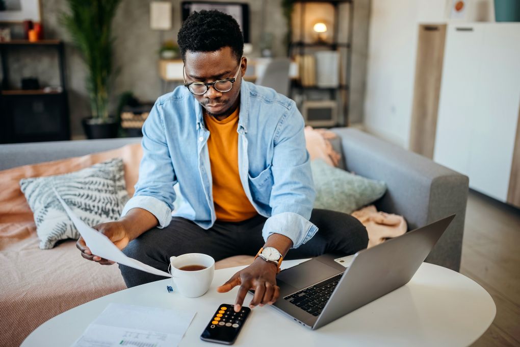 Young man calculating the interest on his investment