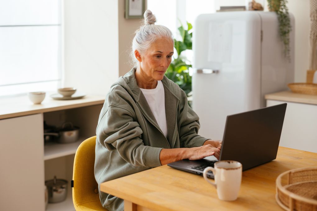 Retired woman reading about markets on a computer
