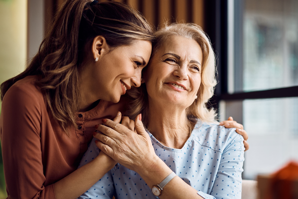 Two women smiling while holding each other closely