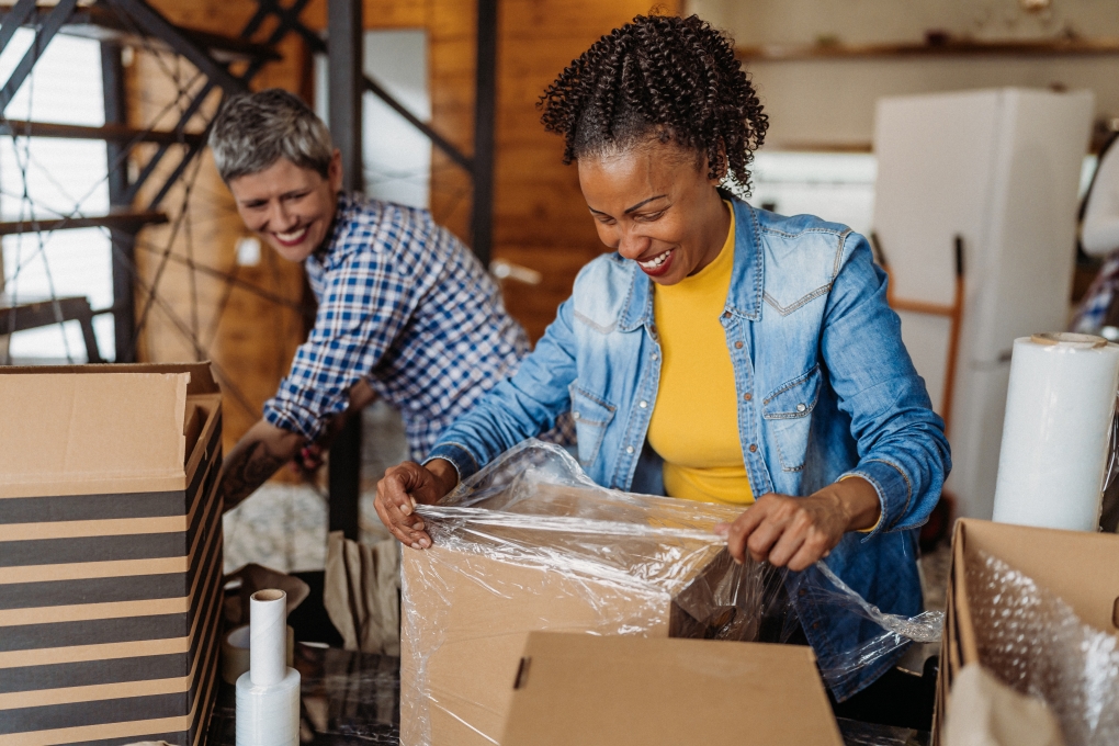 img-moving-cost Photo for article on the cost of moving illustrating two women packing boxes