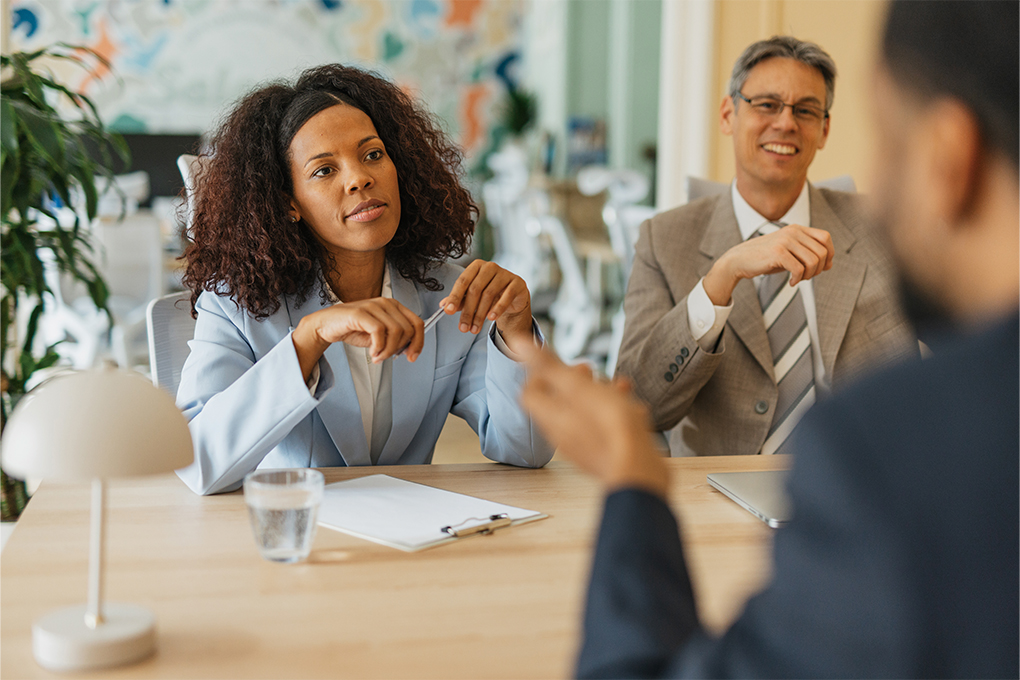 Discussion between three people around a table in an office.