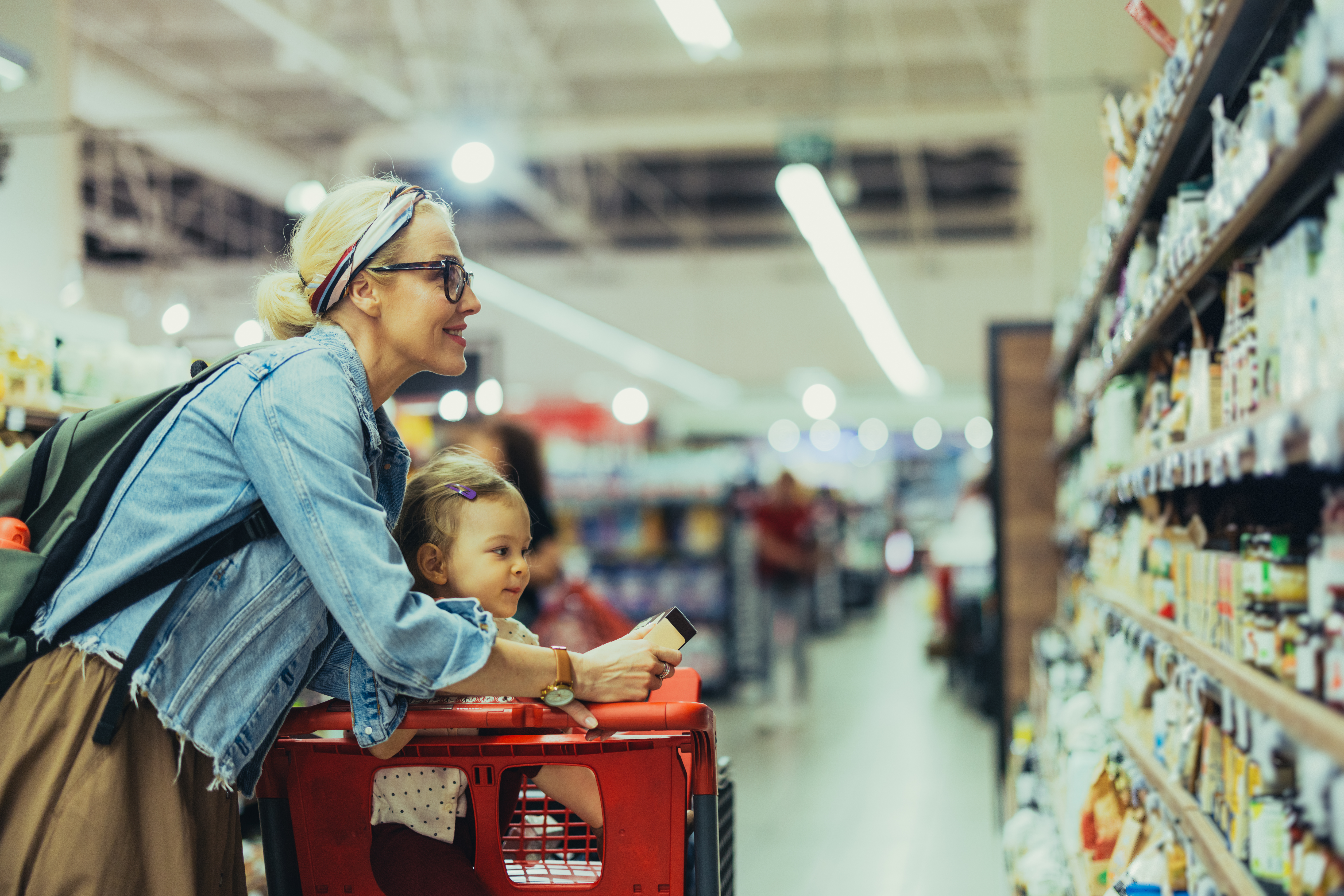 Mother and child comparing food prices at the grocery store