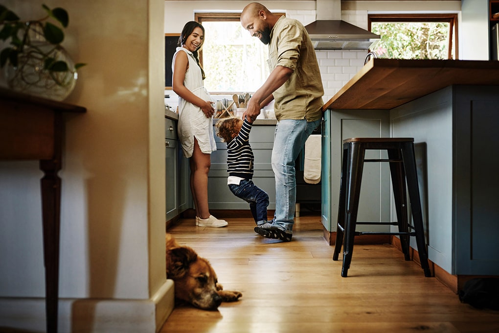 Couple and a child standing in their kitchen 
