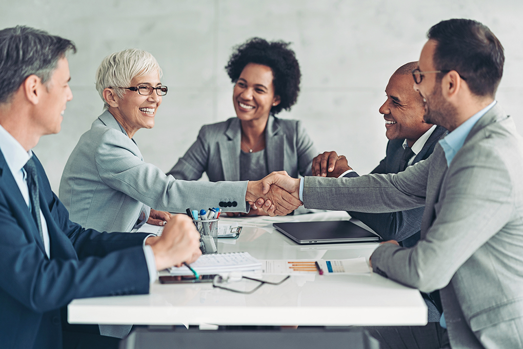 Five professionals sitting around a desk