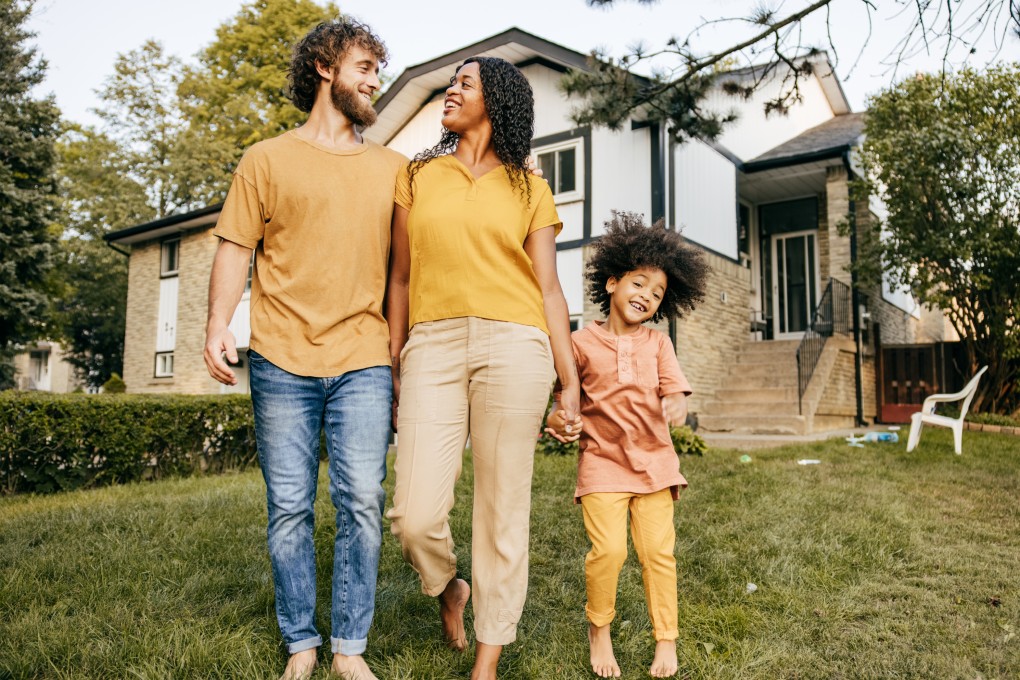 A newly Canadian family enjoys the nice weather in front of the house.