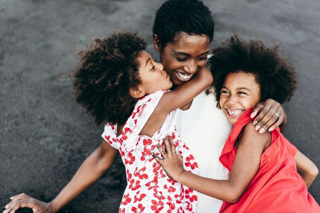 Mother and her two young daughters laughing and having fun